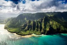 green mountains and blue ocean surrounding island of hawaii