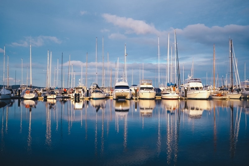 Sailing boats in a single file lined up along the dock at Hobart Harbour in Australia