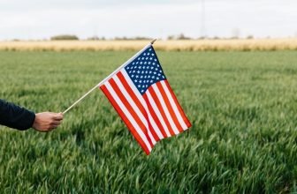 Person holding the US flag in a field