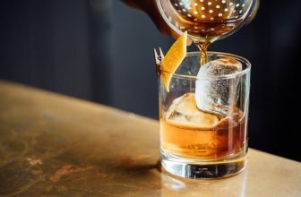 Alcoholic drink being poured on the rocks.