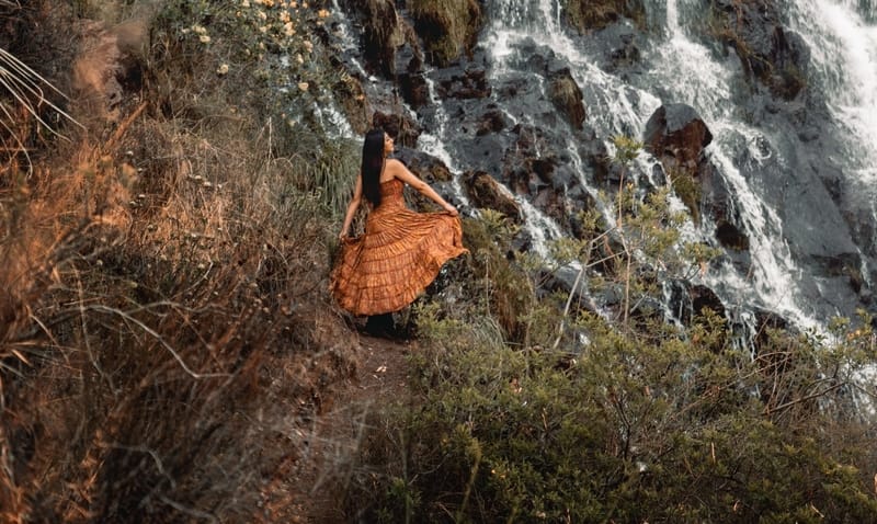 Woman dancing in front of waterfall in Peru