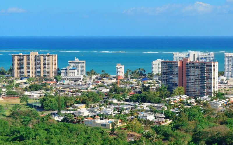 A view of San Juan, Puerto Rico, showing buildings, greenery, and the sea
