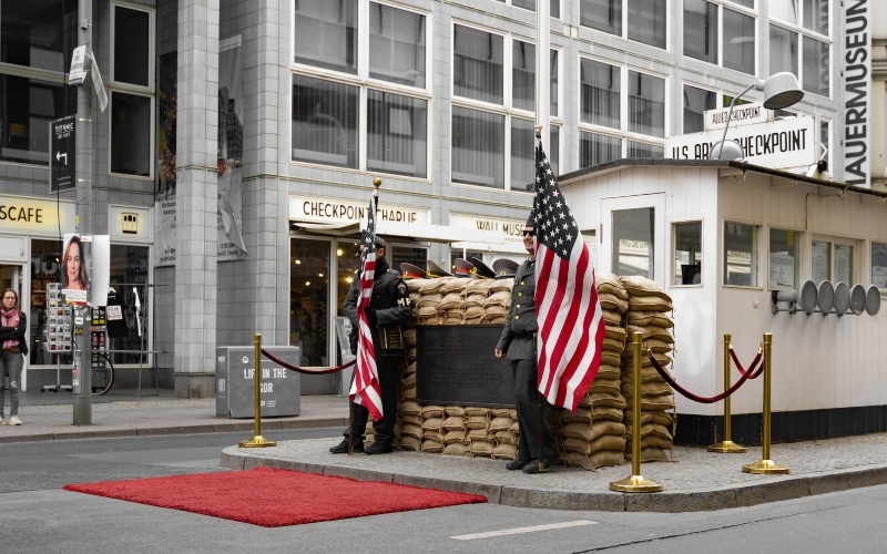 The site of Checkpoint Charlie in Berlin featuring two soldiers holding American flags