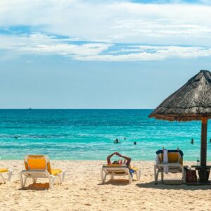 A view of the beach and Caribbean sea with beach chairs in Cancun, Mexico
