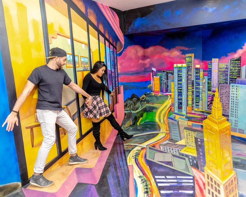 People walking along the optical illusions painted on the walls in the Miami Museum of Illusions
