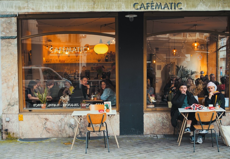 A busy café in Antwerp, Belgium with people sitting at a table outside 