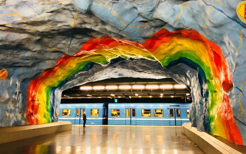 A painted rainbow and blue train in Stockholm subway
