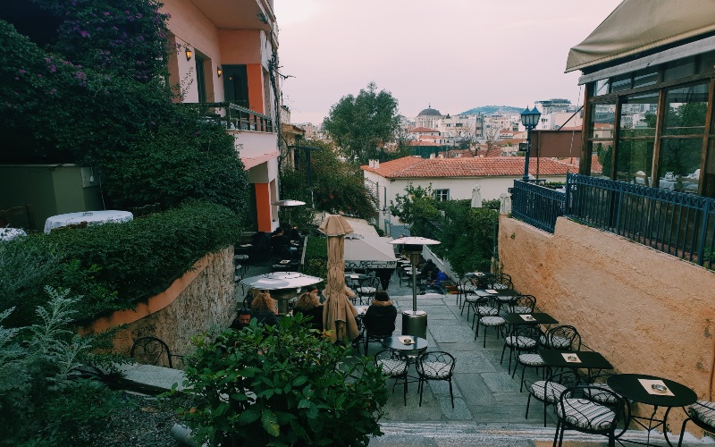 a slightly muted image of an outdoor cafe with greens and a setting sun