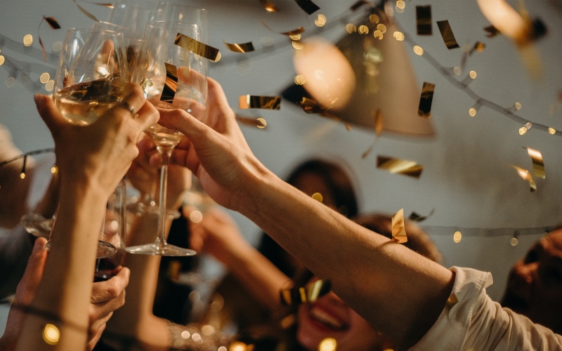 Closeup of people doing a cheers with glass of champagne for New Year's Eve