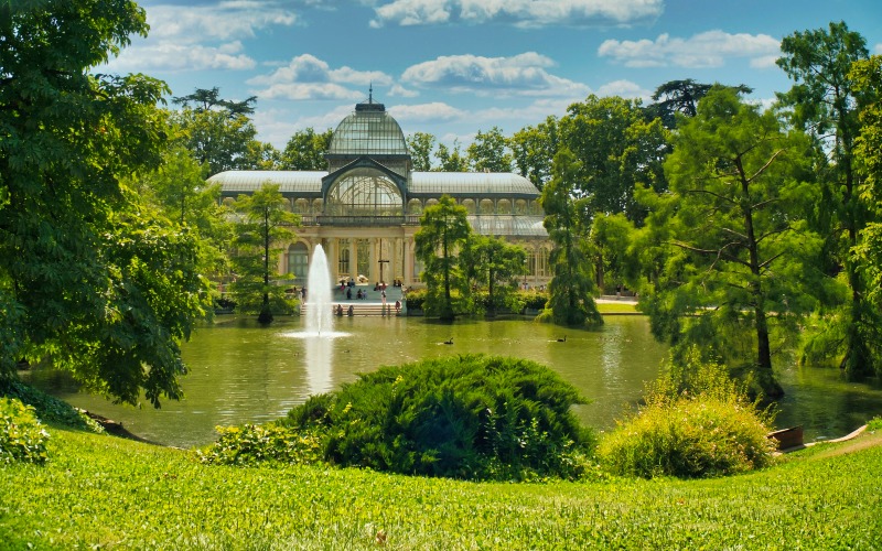 View of the greenery of Retiro Park and it's glass palace in Madrid
