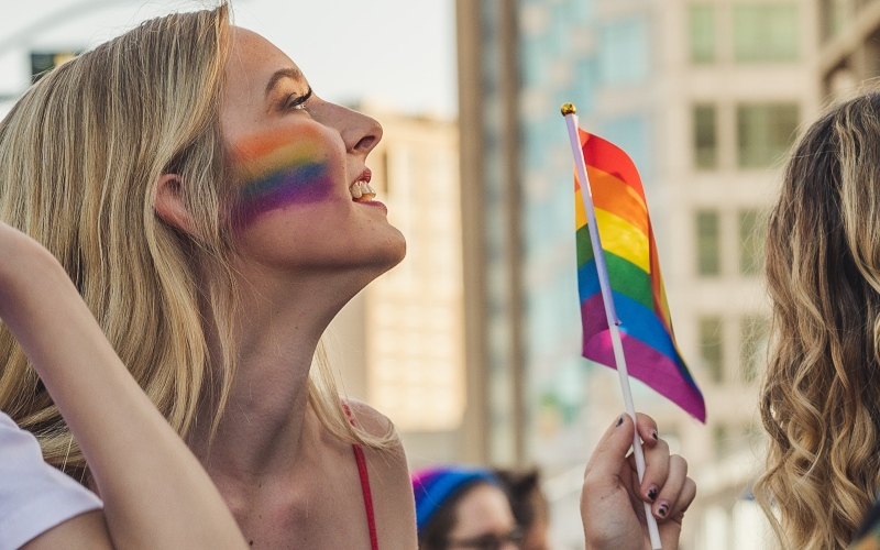 Closeup of a person waving a pride flag during celebrations