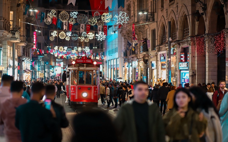 a christmas setting with a popular red tram foregrounding the photo and a crowd around it