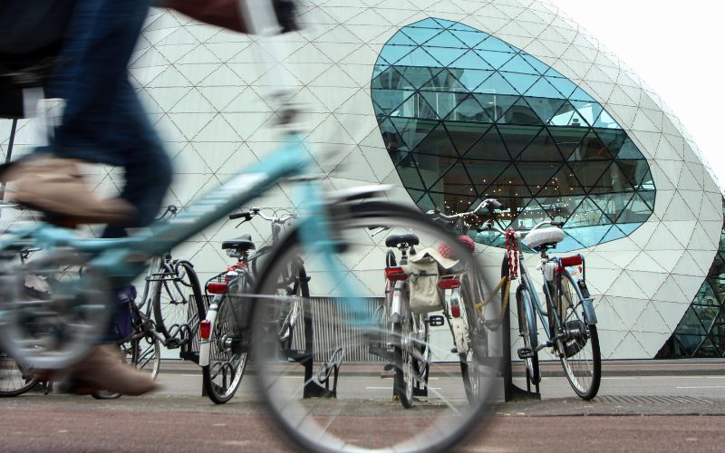 A cyclist ridding past the Blob building in Eindhoven.