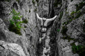 Man in gray swinging down canyon