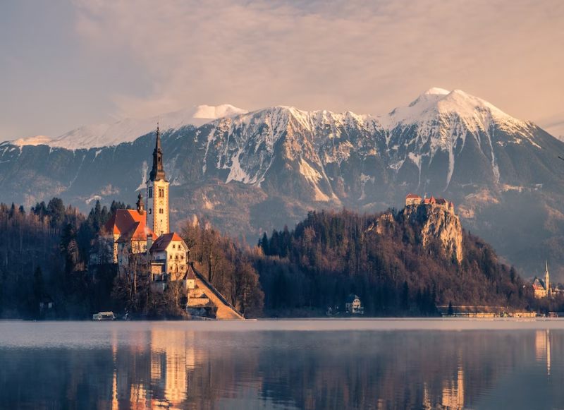 beautiful building overlooking the lake and alps in slovenia